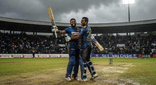 Sri Lankan batsmen celebrating century partnership on pitch